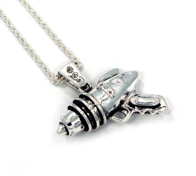 right angled shot of the Ray Gun Pendant in silver on a white surface