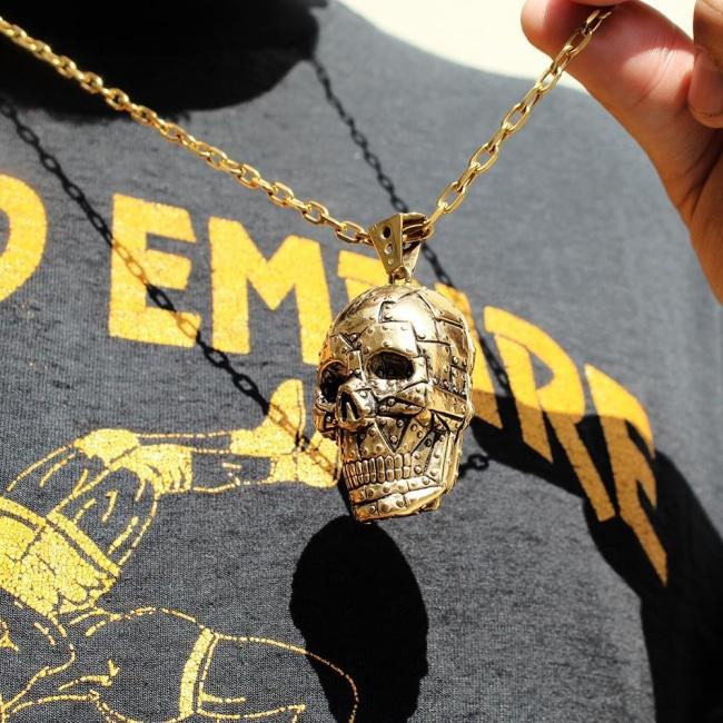 shot of the Rivet Skull Pendant in gold on a man from han cholo skulls collection