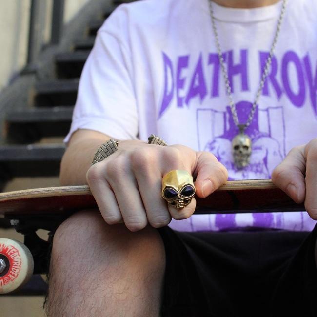 shot of a man wearing the roswell ring in gold and a deathrow records t shirt
