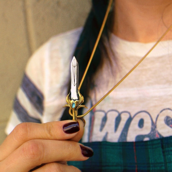 She-ra sword pendant being held by a girl holding the sword by the handle