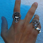 shot of a man wearing the sid skull ring in silver in front of blue smoke