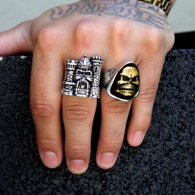 shot of the skeletor and castle grayskull ring on a mans hand holding a black brick
