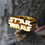 shot of the Star Wars Logo Ring in gold on a grey background from the star wars collection