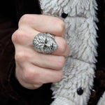 shot of a man wearing a black jacket with white fur wearing the wolfman ring