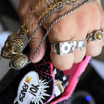 shot of a man holding shoes wearing the turntable ring and other necklaces from han cholo