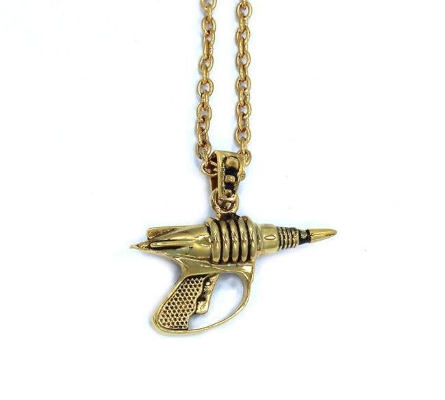 back view of the Zap pendant in gold on a white surface