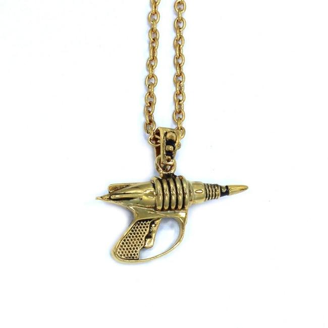 back view of the Zap pendant in gold on a white surface