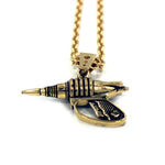 up close shot of the Zap pendant in gold on a white surface