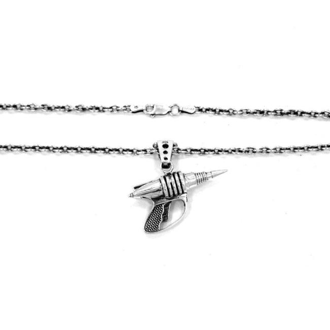 shot of the zap pendant in silver showing the clasp of the sterling cable chain on a white surface